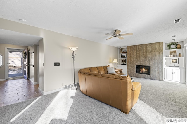 living room with a fireplace, a textured ceiling, ceiling fan, and carpet flooring