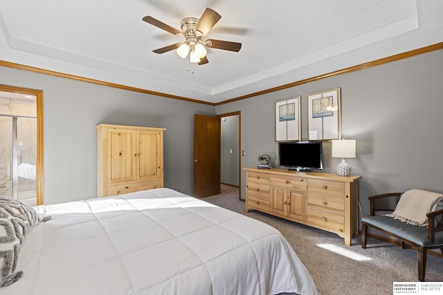 carpeted bedroom with a raised ceiling, ceiling fan, ensuite bath, and crown molding