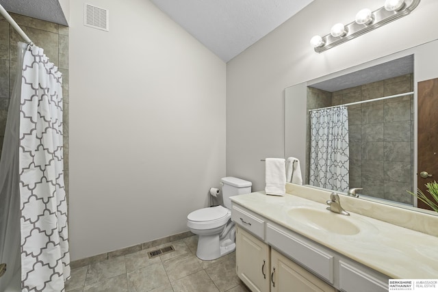 bathroom featuring tile patterned flooring, toilet, walk in shower, vanity, and a textured ceiling