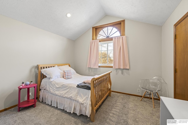 bedroom with a textured ceiling, vaulted ceiling, and carpet flooring