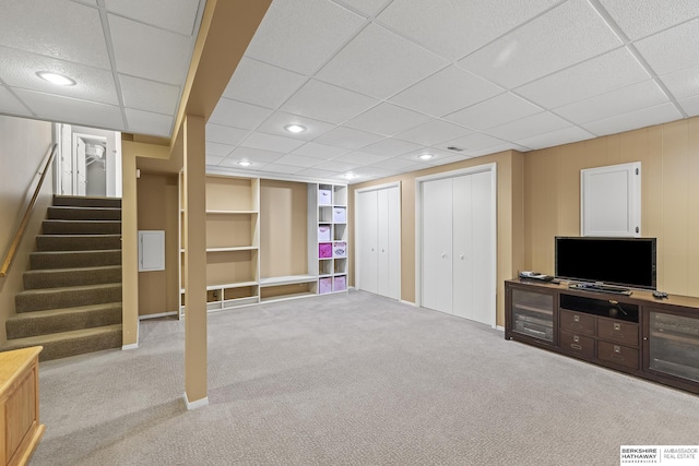 basement featuring built in shelves and light colored carpet