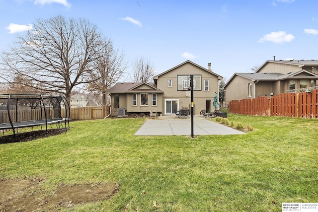 rear view of property featuring central air condition unit, a patio area, a yard, and a trampoline