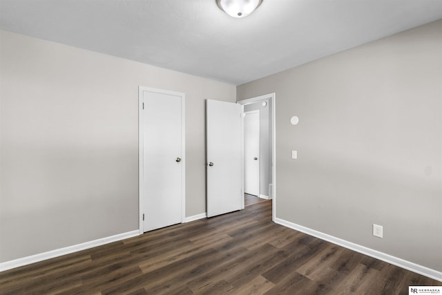 unfurnished room with dark wood-type flooring