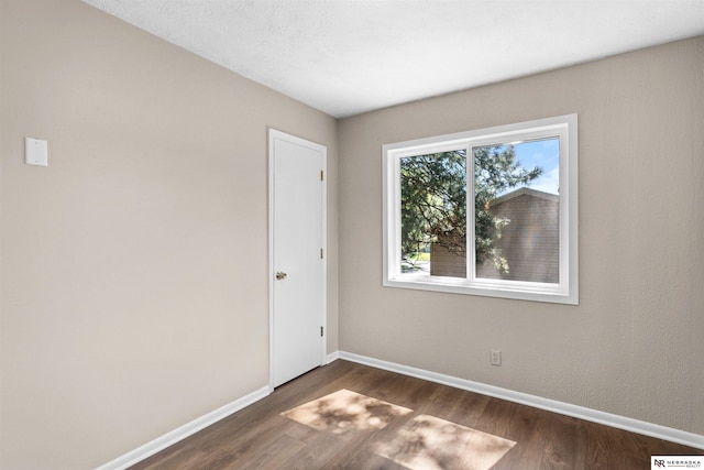 spare room featuring dark wood-type flooring