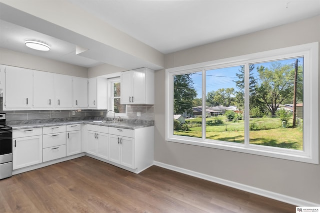 kitchen with decorative backsplash, range with electric cooktop, dark hardwood / wood-style flooring, sink, and white cabinets