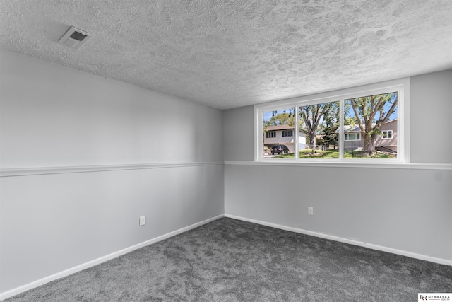 carpeted empty room with a textured ceiling