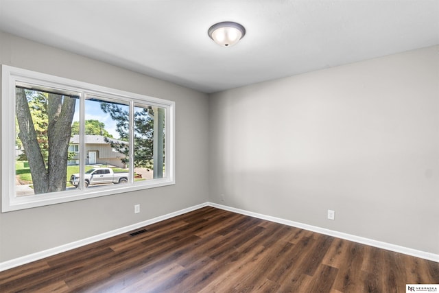 unfurnished room featuring plenty of natural light and dark hardwood / wood-style floors