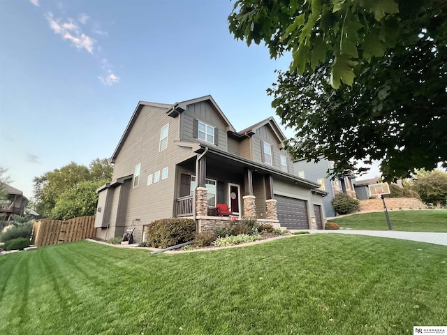 craftsman-style house featuring a front yard, a porch, and a garage