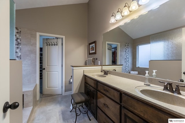 bathroom with tile patterned flooring, vanity, and vaulted ceiling