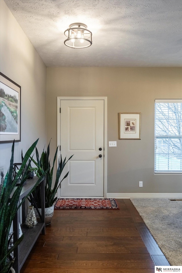 entrance foyer featuring dark hardwood / wood-style floors and a textured ceiling