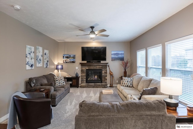 living room with ceiling fan and a stone fireplace