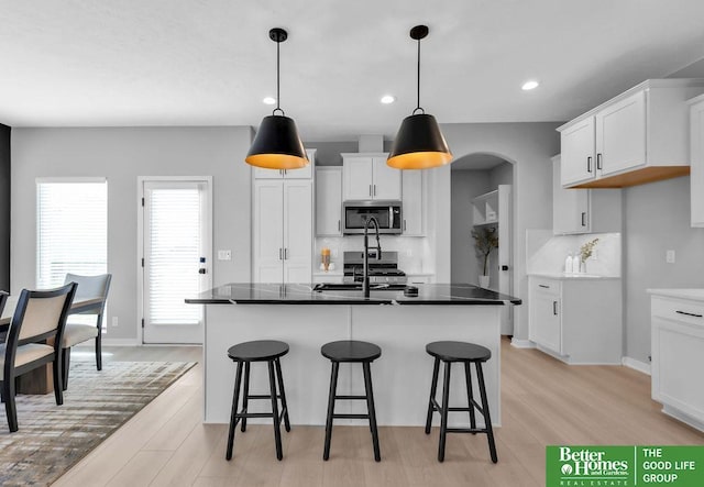 kitchen featuring sink, white cabinetry, a kitchen island with sink, and light hardwood / wood-style flooring