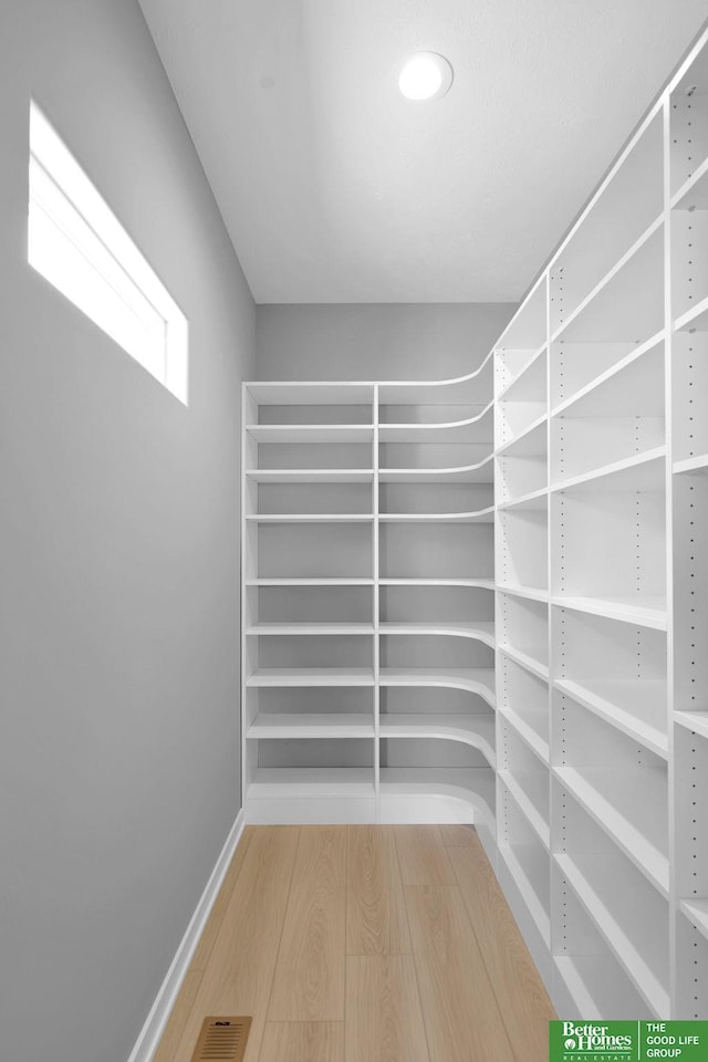 spacious closet featuring hardwood / wood-style flooring