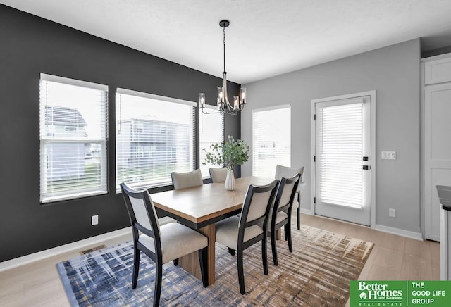 dining area featuring light hardwood / wood-style floors and a chandelier