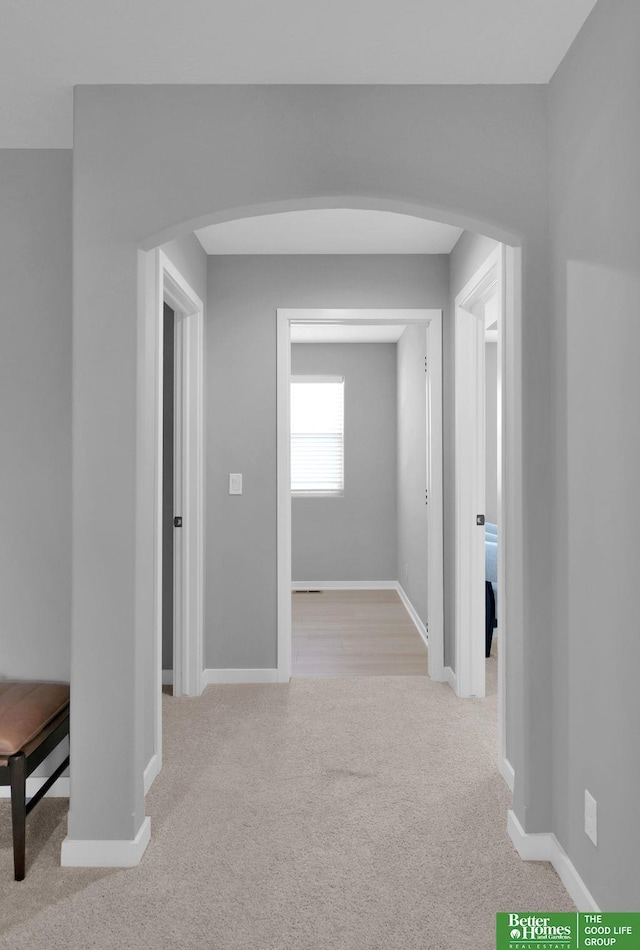 hall with light colored carpet