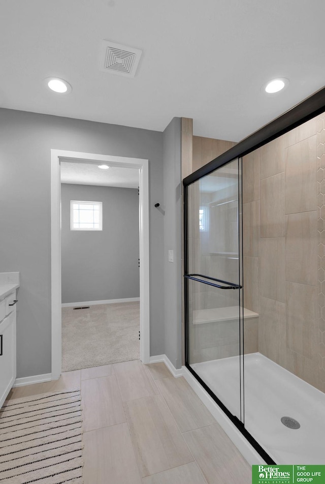 bathroom with tile patterned flooring, vanity, and a shower with door