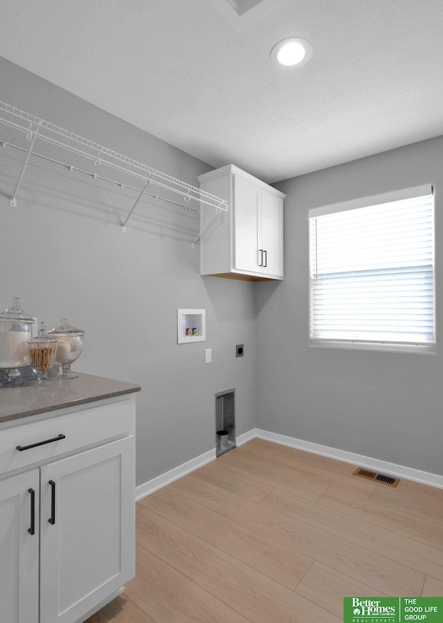 washroom with hookup for an electric dryer, light wood-type flooring, and washer hookup