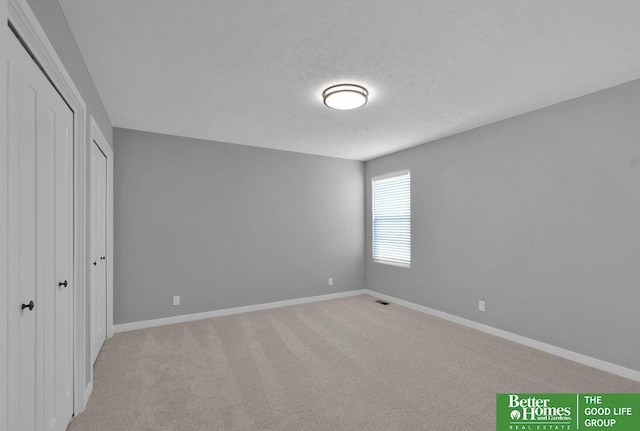 unfurnished bedroom with light colored carpet