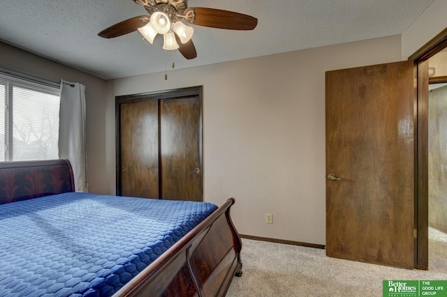 carpeted bedroom featuring a textured ceiling, a closet, and ceiling fan