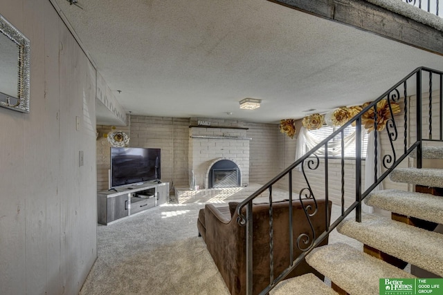 carpeted living room featuring a textured ceiling and a brick fireplace