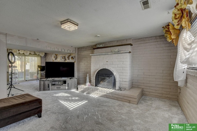 carpeted living room featuring a fireplace, a textured ceiling, and brick wall