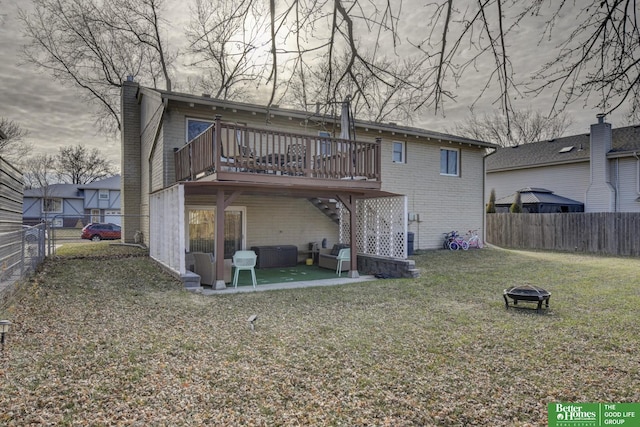 rear view of house featuring a patio, a yard, an outdoor fire pit, and a wooden deck