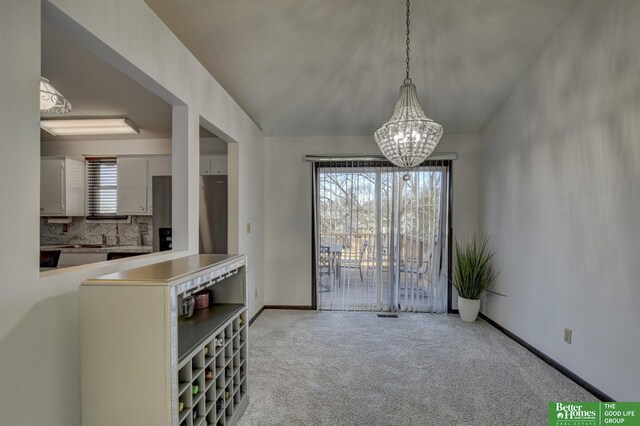 dining area featuring light colored carpet and an inviting chandelier