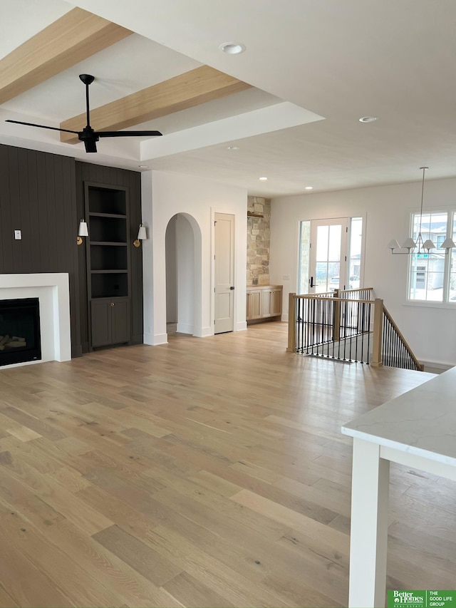 unfurnished living room featuring ceiling fan, a fireplace, and light hardwood / wood-style floors