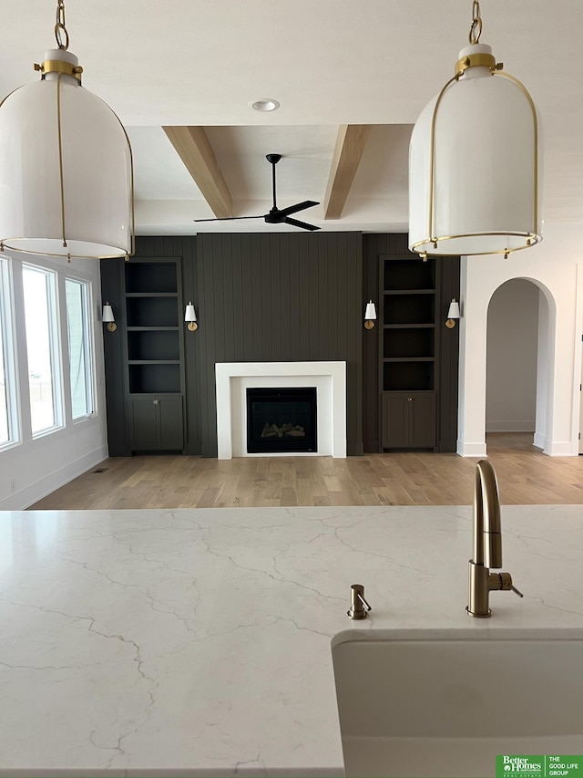 kitchen with beamed ceiling, ceiling fan, sink, and hardwood / wood-style floors