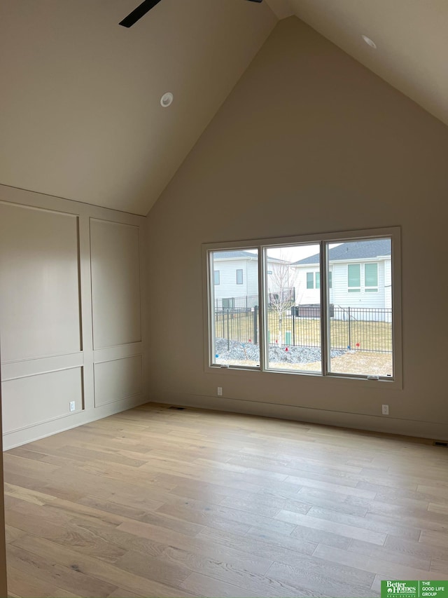 unfurnished room featuring light hardwood / wood-style flooring and high vaulted ceiling