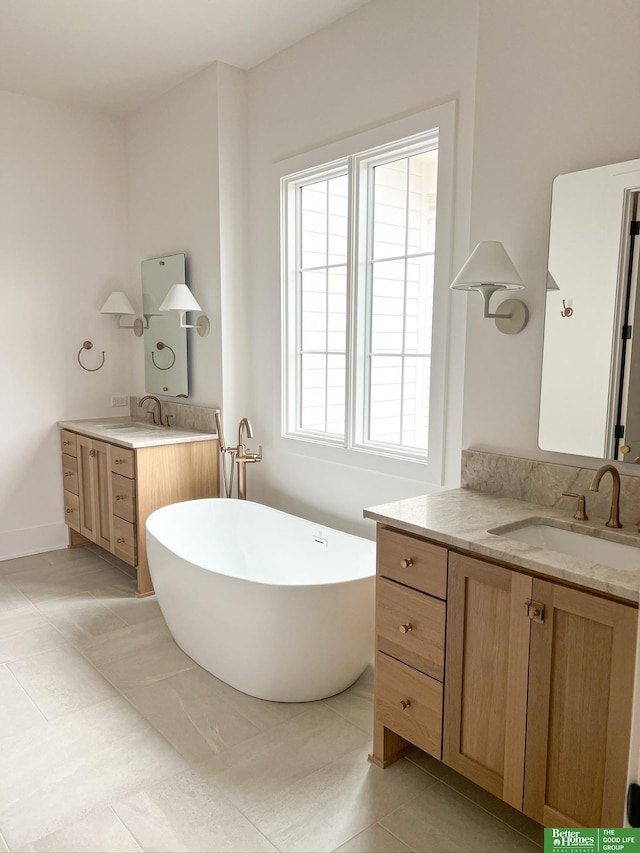 bathroom featuring tile patterned flooring, a bathtub, and vanity