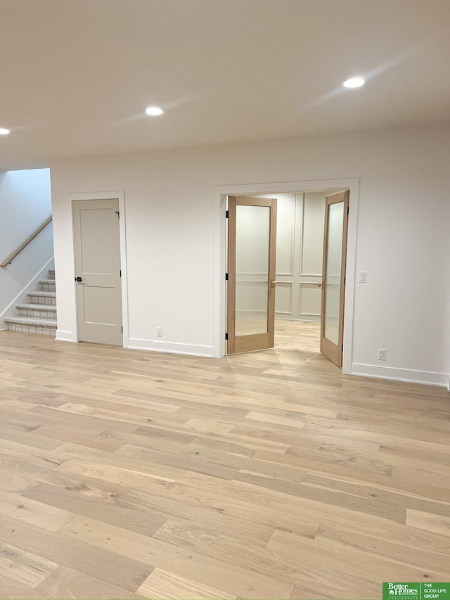 unfurnished room featuring french doors and light hardwood / wood-style flooring