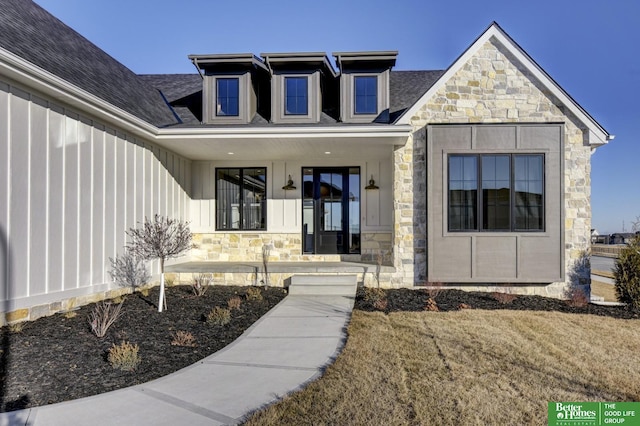 property entrance featuring a lawn and covered porch