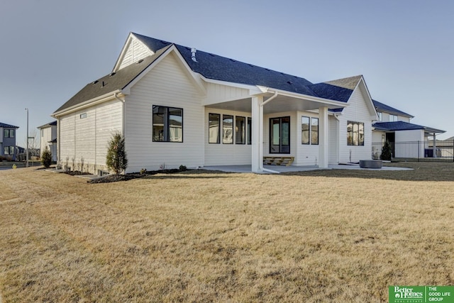 rear view of house with a lawn and a patio area