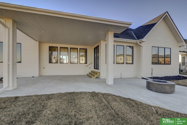 back of property featuring a patio and a fire pit