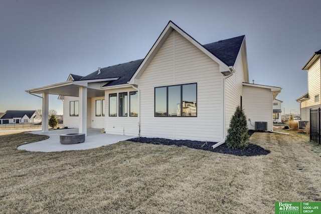 back of property featuring a lawn, cooling unit, and a patio