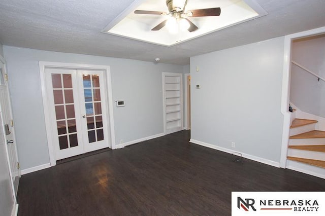 spare room with french doors, built in shelves, a textured ceiling, ceiling fan, and dark hardwood / wood-style floors