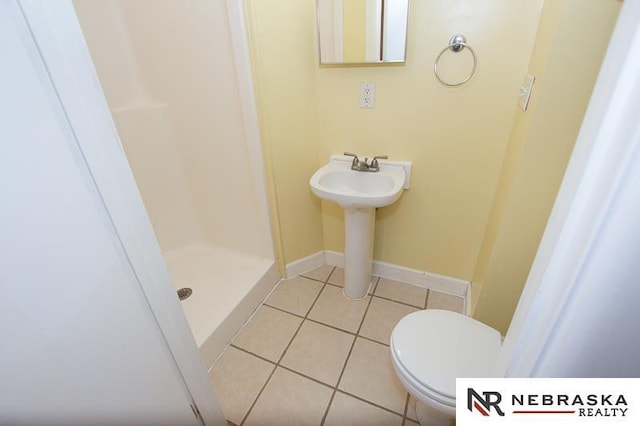 bathroom featuring tile patterned flooring, sink, toilet, and a shower