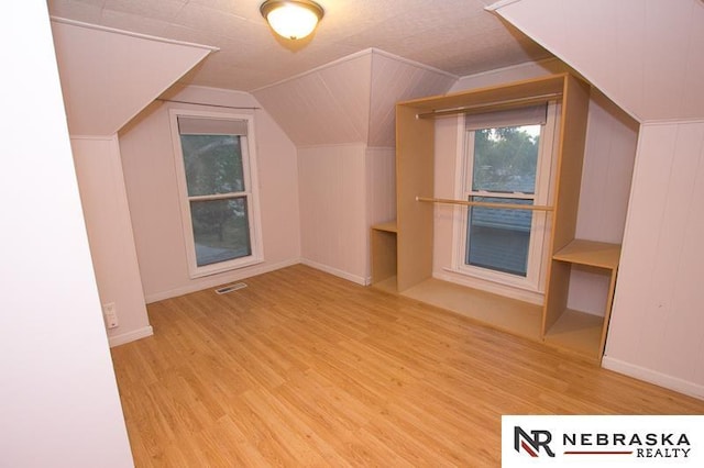 bonus room with light hardwood / wood-style floors and lofted ceiling