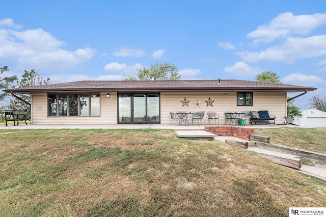 rear view of property with a lawn and a patio