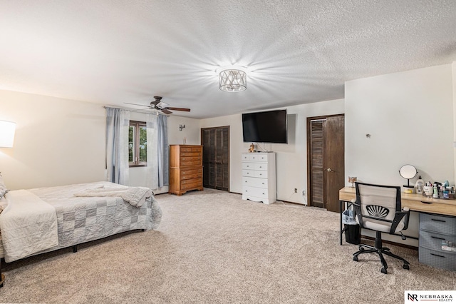 bedroom with carpet flooring, ceiling fan, and a textured ceiling