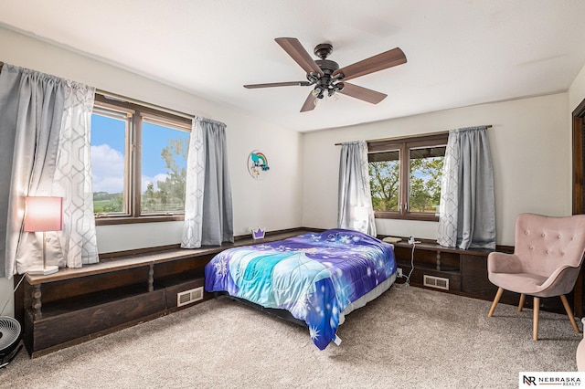 carpeted bedroom featuring ceiling fan and multiple windows