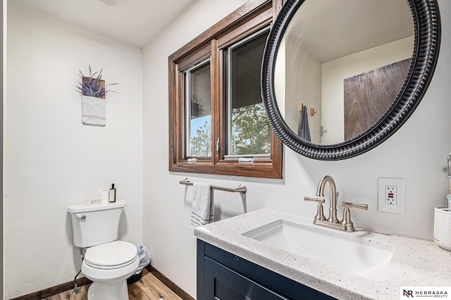 bathroom featuring wood-type flooring, vanity, and toilet