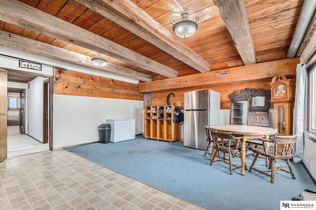 unfurnished dining area featuring carpet, beamed ceiling, and wood ceiling