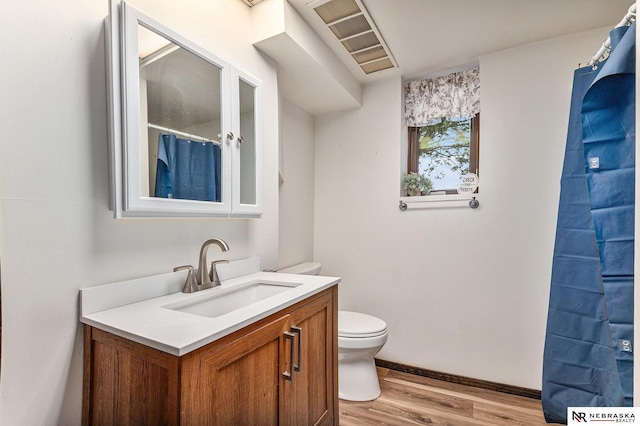 bathroom featuring hardwood / wood-style floors, vanity, and toilet