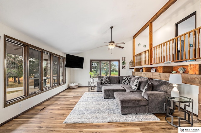 living room featuring ceiling fan, wood-type flooring, and vaulted ceiling