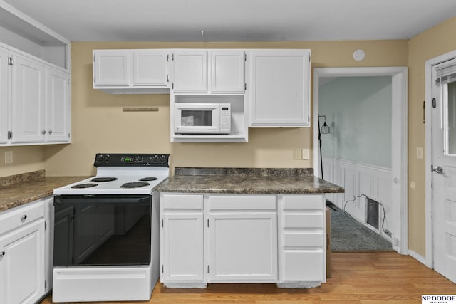 kitchen with white cabinets, light wood-type flooring, and white appliances