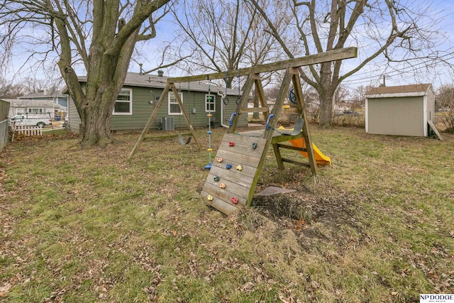 view of playground with central AC, a yard, and a storage shed