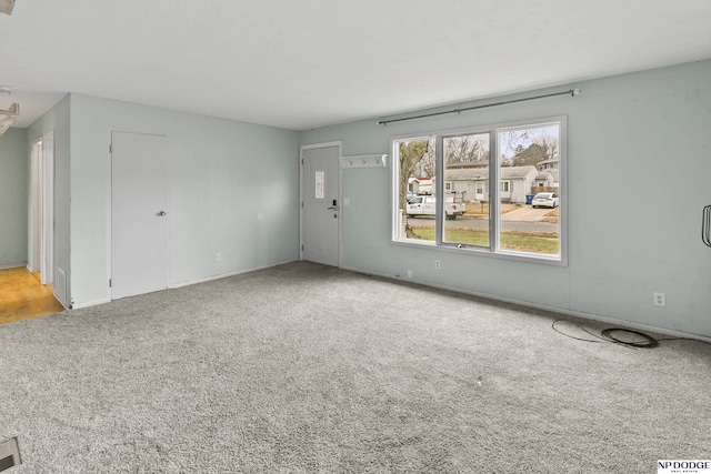 unfurnished living room featuring light colored carpet