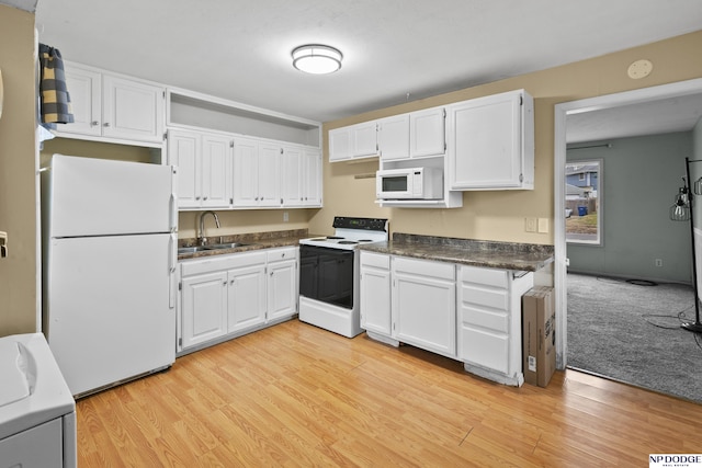 kitchen with sink, white cabinets, white appliances, and washer / dryer